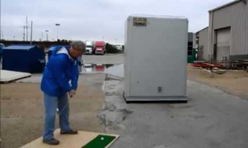 Demonstrating a shelter's ability to withstand damage and protect equipment from stray golf balls